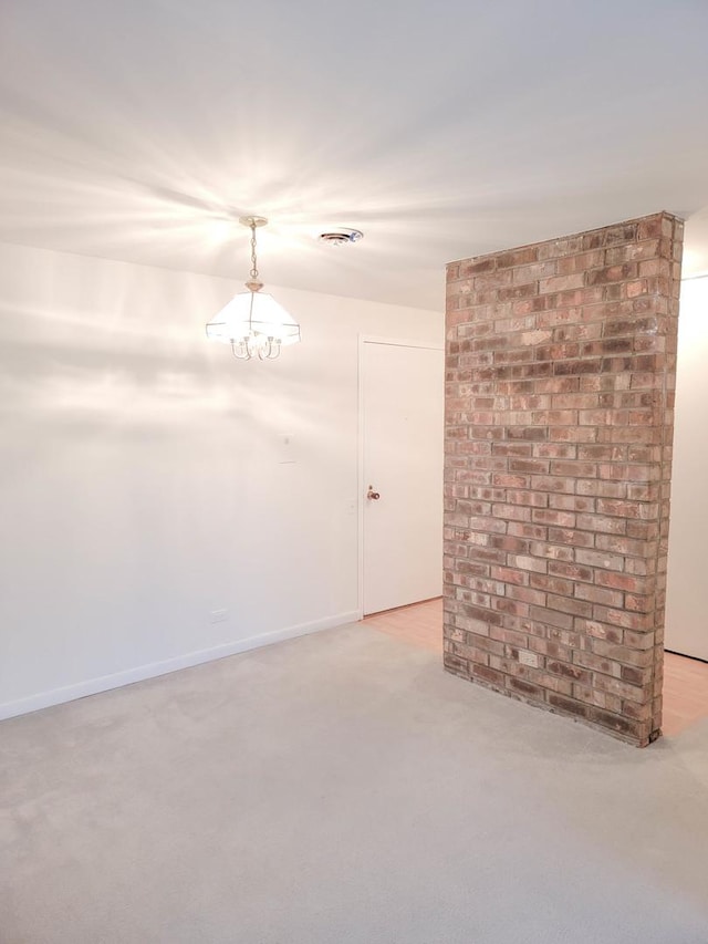 carpeted empty room with a chandelier