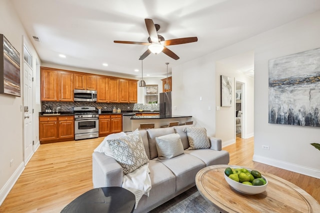 living room featuring ceiling fan and light wood-type flooring