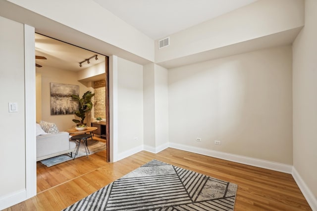 interior space featuring hardwood / wood-style floors and rail lighting