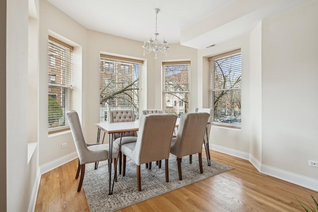 dining area featuring a chandelier and light wood-type flooring