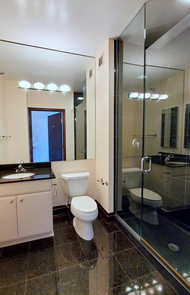 bathroom with toilet, walk in shower, and vanity