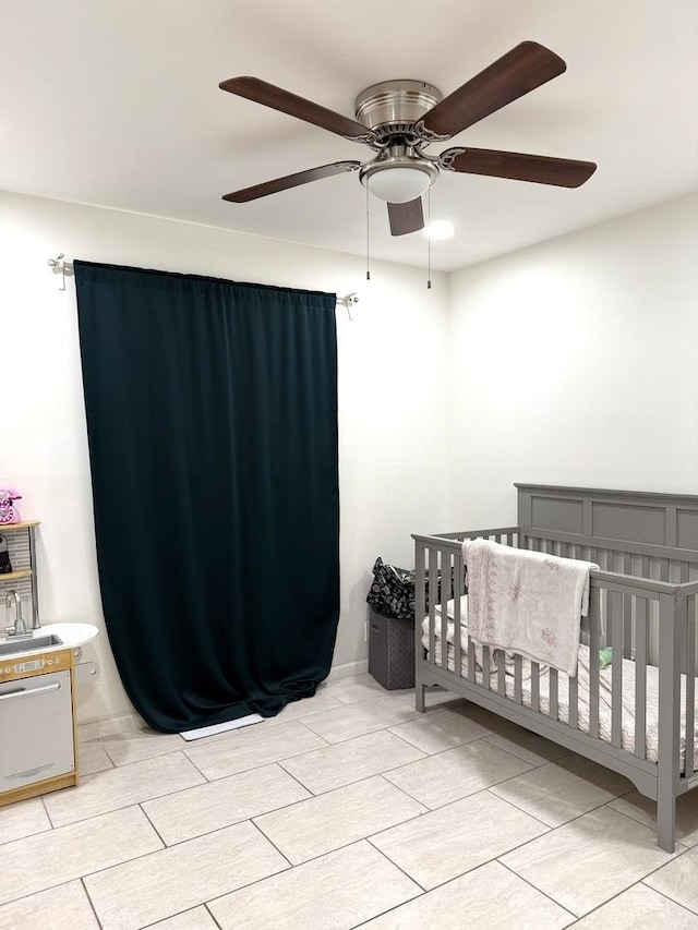 bedroom featuring a crib and a ceiling fan