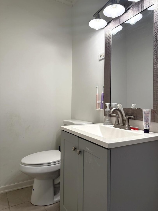 bathroom featuring tile patterned flooring, toilet, vanity, and baseboards