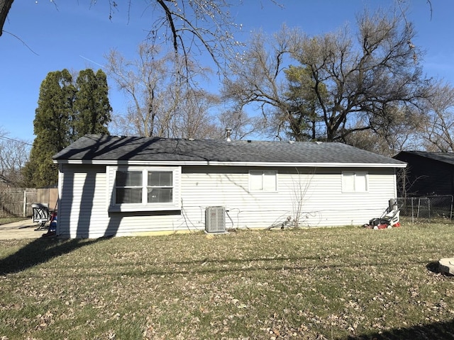 back of house featuring cooling unit, a lawn, and fence