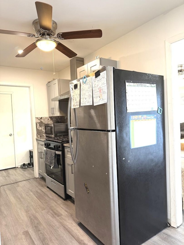 kitchen featuring tasteful backsplash, gray cabinets, appliances with stainless steel finishes, and light wood-style floors