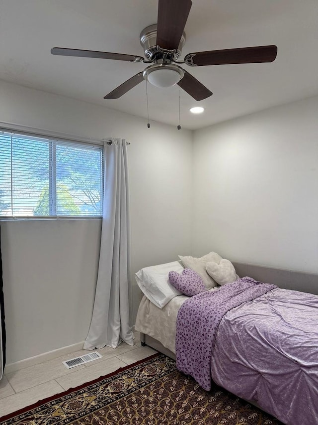 bedroom featuring light tile patterned floors, visible vents, and a ceiling fan