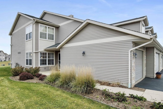 view of property exterior featuring a garage and a lawn