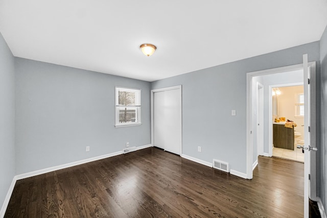 unfurnished bedroom featuring dark hardwood / wood-style floors and a closet