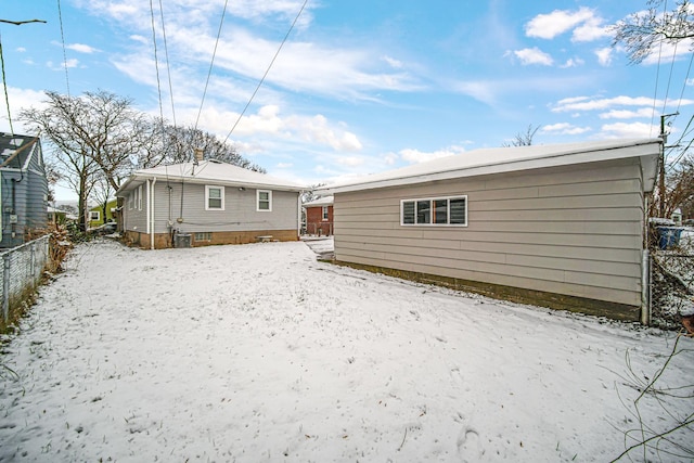 view of snow covered back of property