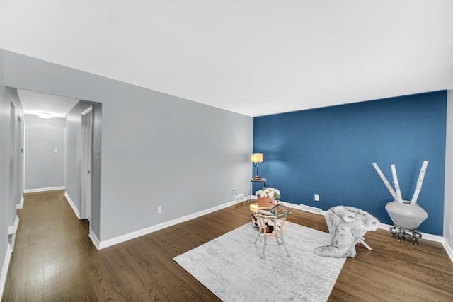 sitting room with dark wood-type flooring