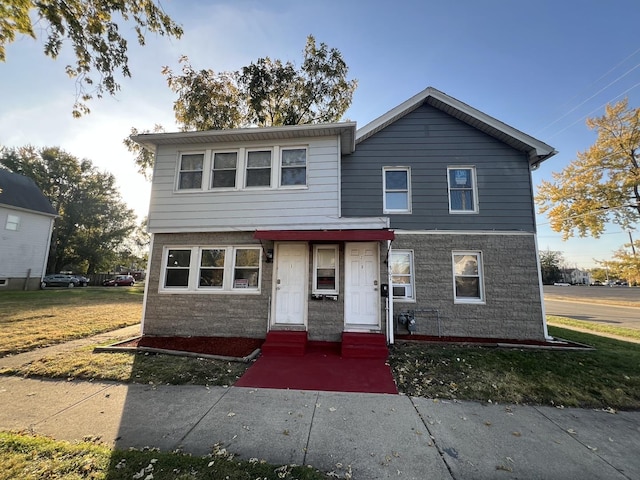 view of property featuring a front lawn