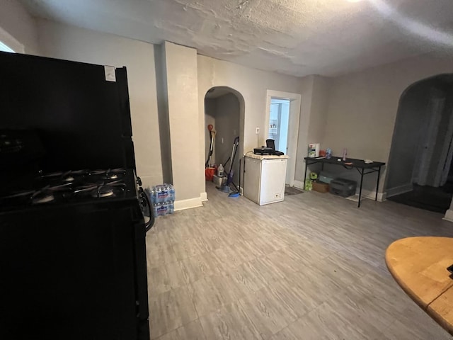 interior space with a textured ceiling and light hardwood / wood-style flooring