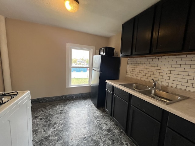 kitchen with backsplash, range, sink, and fridge