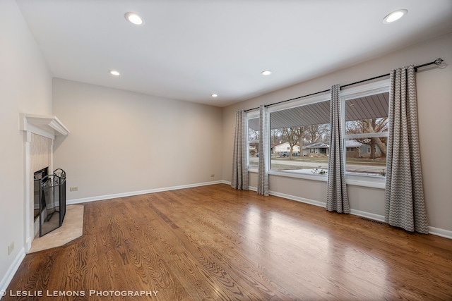 unfurnished living room with a high end fireplace and hardwood / wood-style flooring