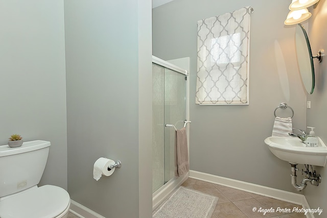 bathroom featuring sink, toilet, a shower with shower door, and tile patterned floors