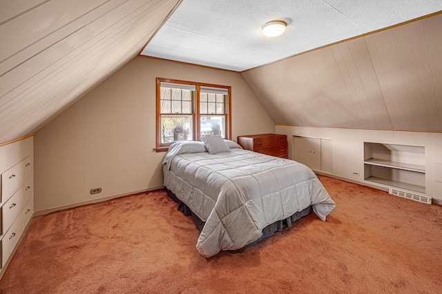 bedroom with a textured ceiling, light colored carpet, and lofted ceiling