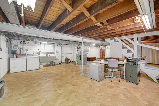 basement with heating unit, sink, and washing machine and clothes dryer