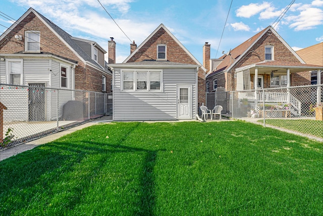 back of property featuring a lawn and covered porch