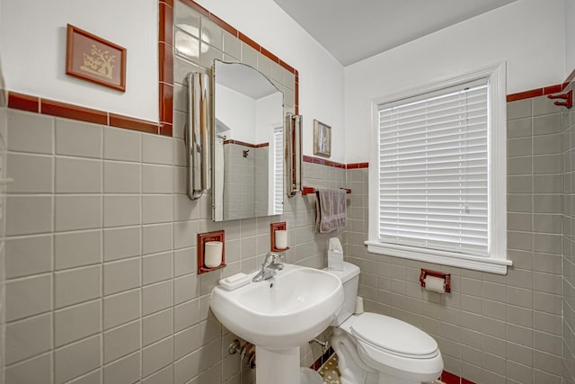 bathroom featuring toilet and tile walls