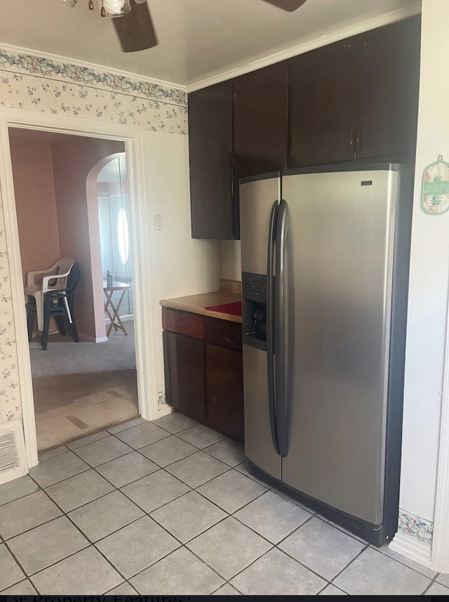 kitchen featuring dark brown cabinetry, stainless steel fridge, ceiling fan, and light tile patterned floors