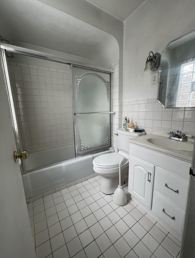 full bathroom featuring tile patterned flooring, combined bath / shower with glass door, toilet, decorative backsplash, and vanity