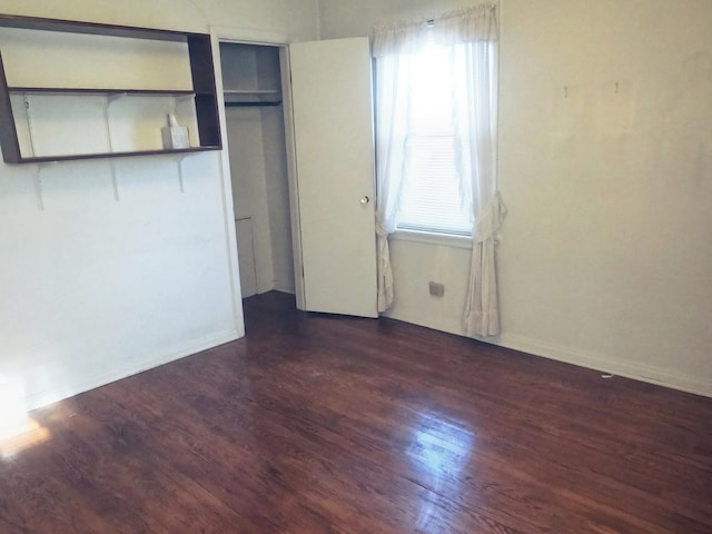 unfurnished bedroom with dark hardwood / wood-style flooring and a closet