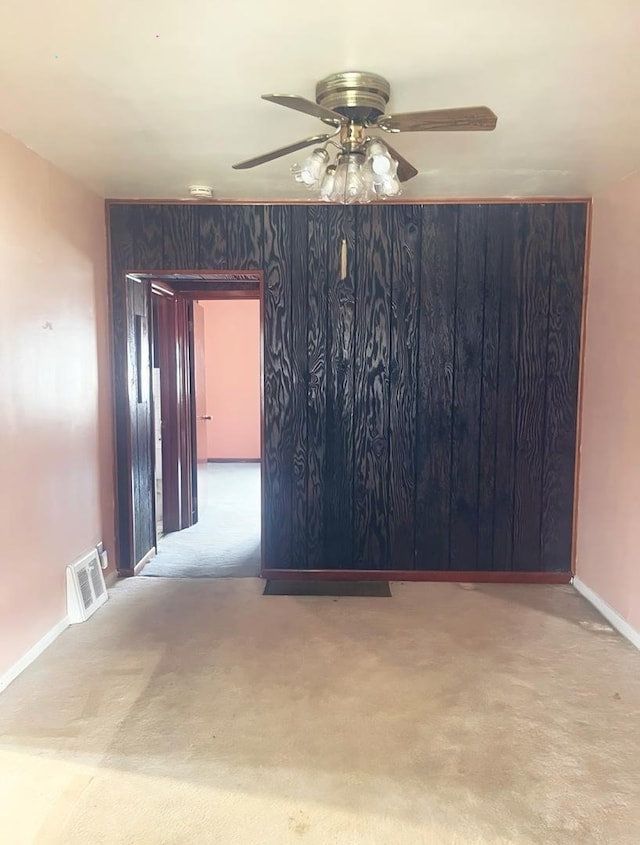 carpeted empty room featuring ceiling fan