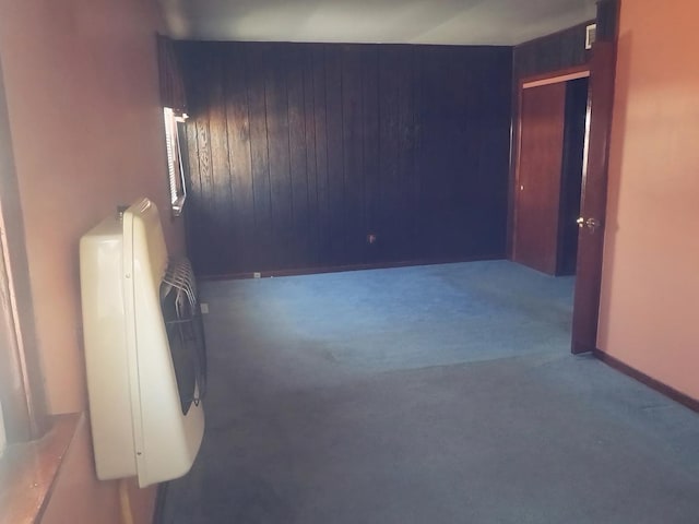 unfurnished room with dark carpet and heating unit