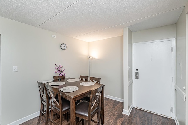 dining area with dark hardwood / wood-style flooring and a textured ceiling