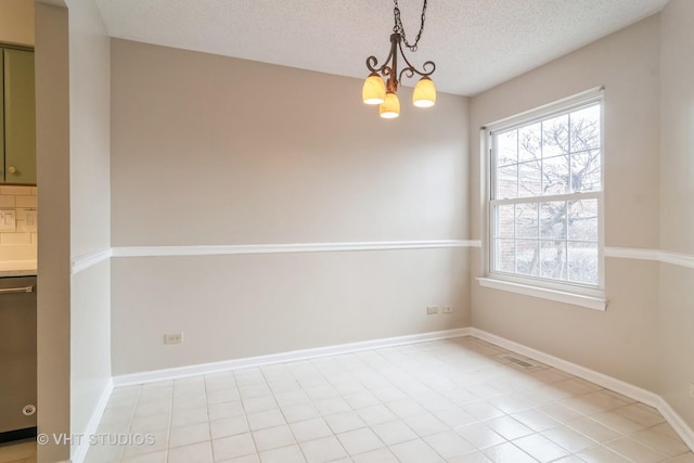 unfurnished room with a chandelier, a textured ceiling, and light tile patterned flooring