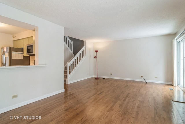 unfurnished living room with hardwood / wood-style floors and a textured ceiling