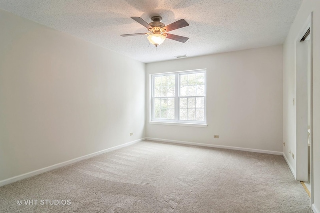 unfurnished bedroom with ceiling fan, light colored carpet, and a textured ceiling