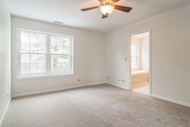 carpeted empty room with a textured ceiling and ceiling fan