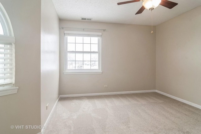 carpeted spare room featuring ceiling fan and a textured ceiling