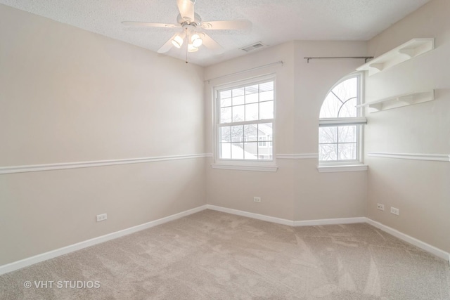 unfurnished room featuring ceiling fan, light colored carpet, and a textured ceiling