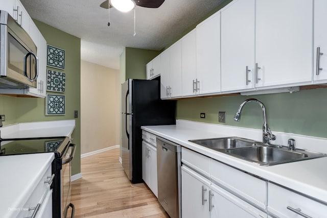 kitchen with light hardwood / wood-style flooring, stainless steel appliances, white cabinetry, and sink