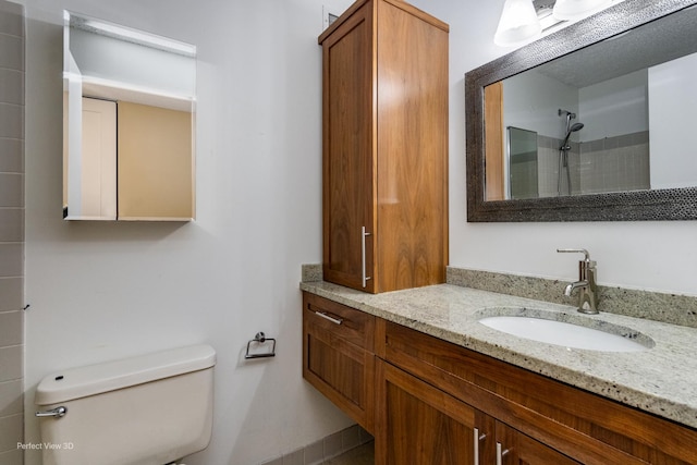 bathroom featuring vanity, toilet, and walk in shower