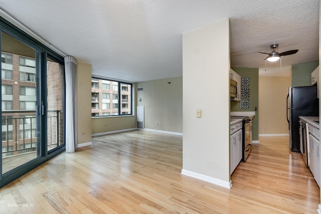 kitchen featuring white cabinets, stainless steel appliances, light hardwood / wood-style flooring, and ceiling fan