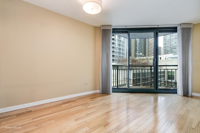 empty room with hardwood / wood-style flooring and expansive windows