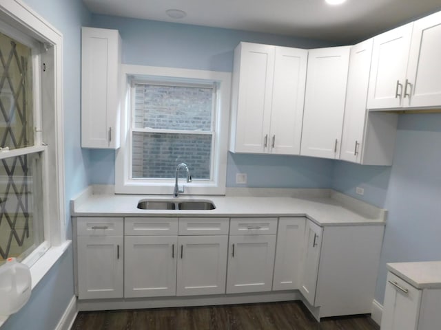 kitchen featuring dark hardwood / wood-style flooring, white cabinetry, and sink