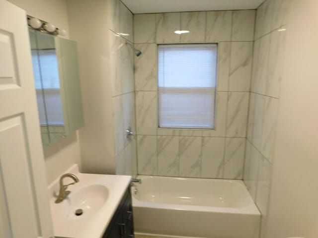 bathroom featuring vanity and tiled shower / bath