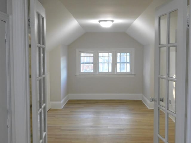 additional living space featuring lofted ceiling and light wood-type flooring