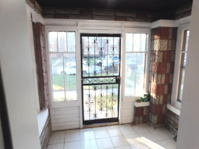 doorway featuring a wealth of natural light and light tile patterned flooring