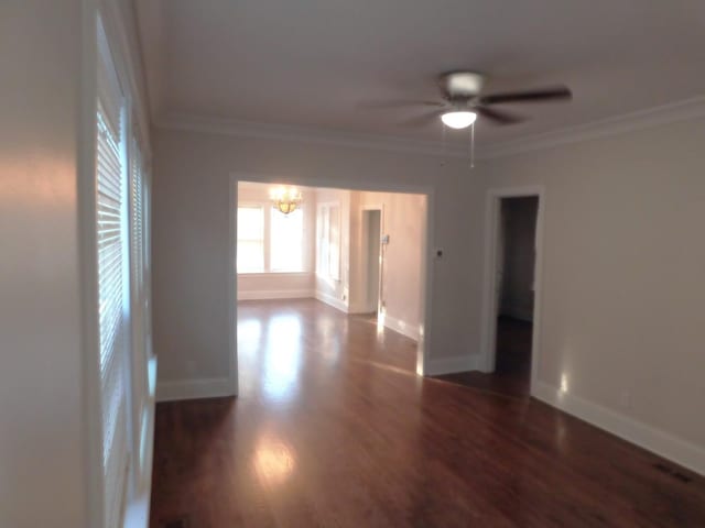 unfurnished room with crown molding, dark wood-type flooring, and ceiling fan with notable chandelier