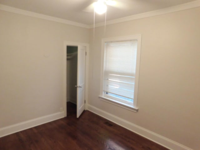 empty room featuring dark hardwood / wood-style flooring and ornamental molding