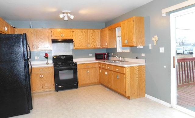 kitchen featuring black appliances, sink, and tasteful backsplash