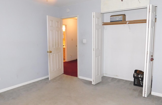 unfurnished bedroom with light colored carpet and a closet