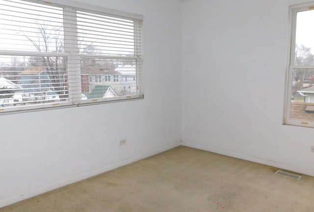 unfurnished room featuring light carpet