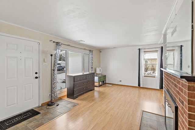 entryway featuring light hardwood / wood-style flooring and a brick fireplace