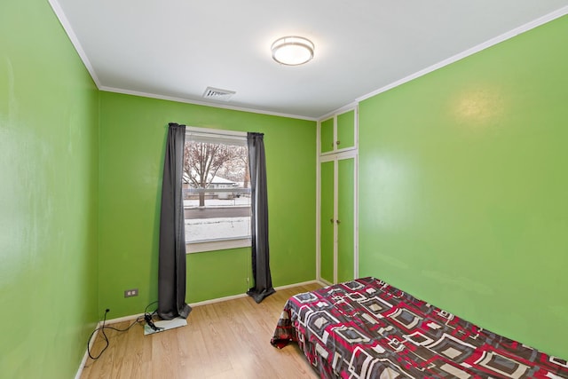 bedroom featuring crown molding and light wood-type flooring